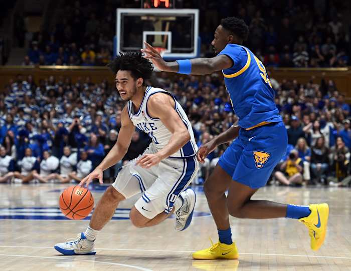 Duke Blue Devils guard Jared McCain dribbles past Pittsburgh Panthers defenders.